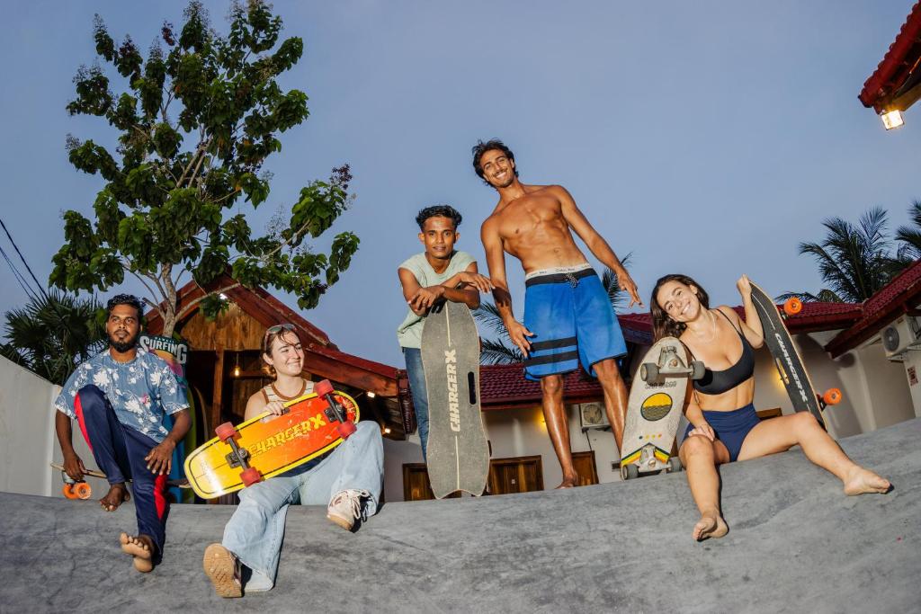 a group of people posing for a picture with skateboards at Hangten's Surf Skate Hostel in Arugam Bay