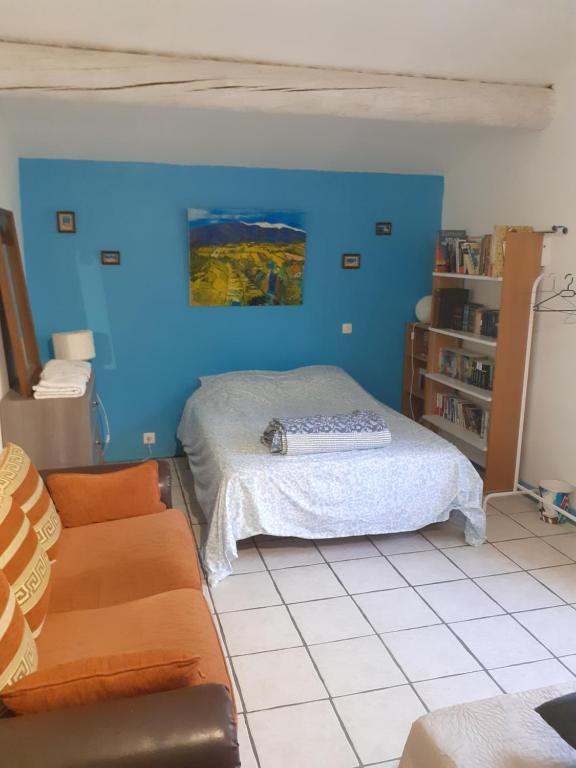 a blue room with a bed and a couch at Le pavillon in Aubignan