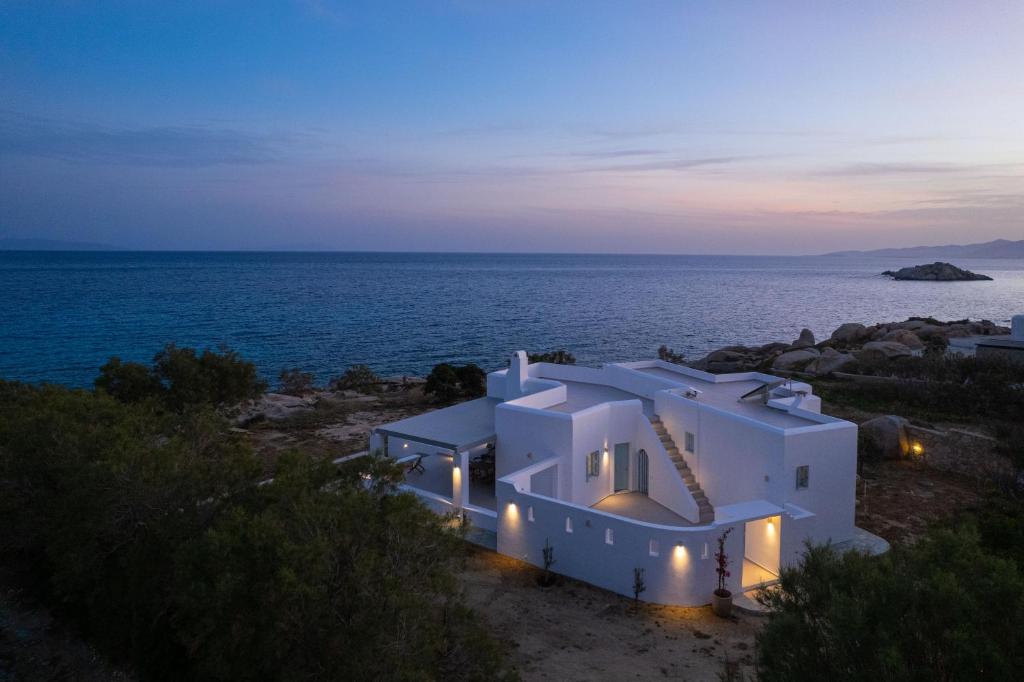 a house on the shore of the ocean at night at Acron Vigla in Mikri Vigla