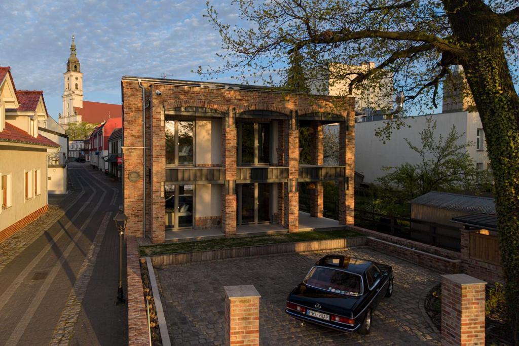 a car parked in front of a brick house at apartamenty64200 in Wolsztyn