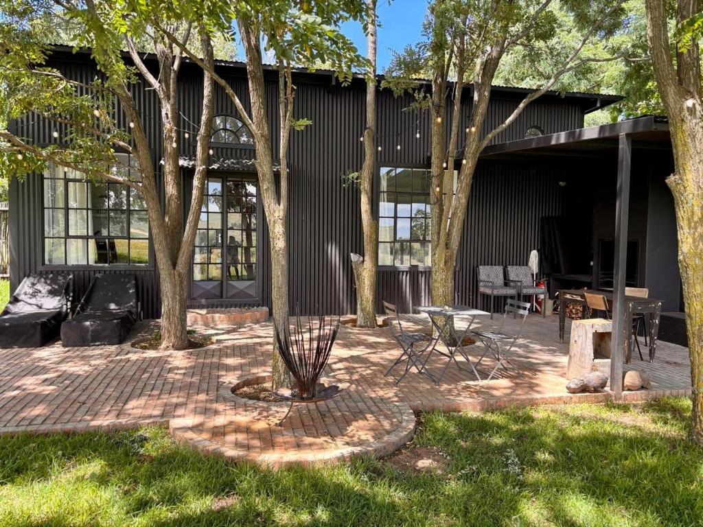 a patio with a table and chairs in front of a building at Field Cabin in Rosendal