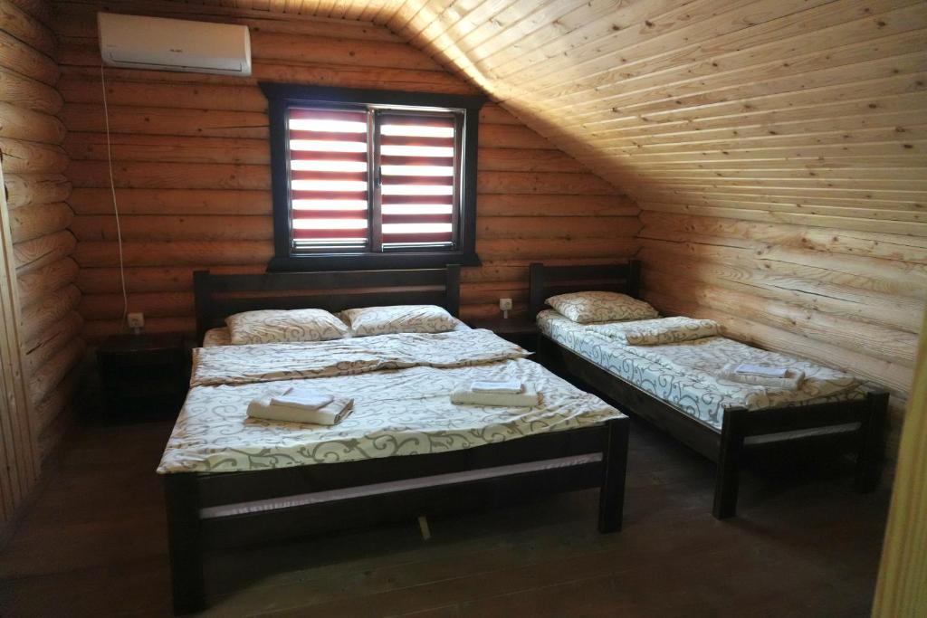 a room with two beds in a log cabin at Сонячна in Solotvyno