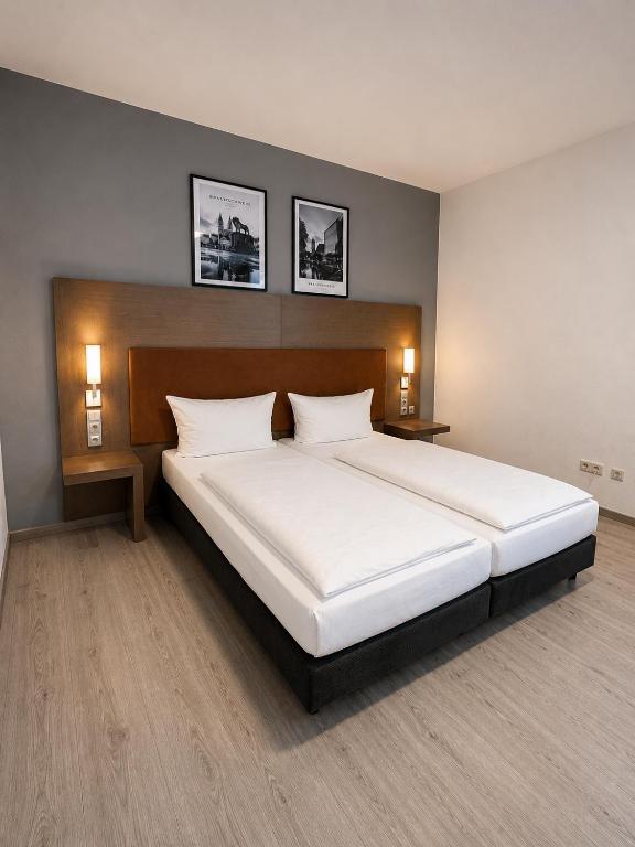 a bedroom with a large white bed with two lamps at An der Stadthalle in Braunschweig