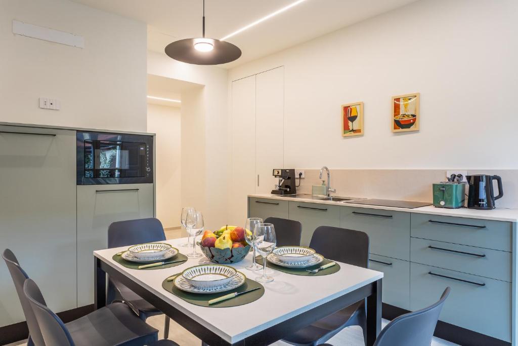 a dining room with a table and chairs and a kitchen at Civico Due in Cuneo