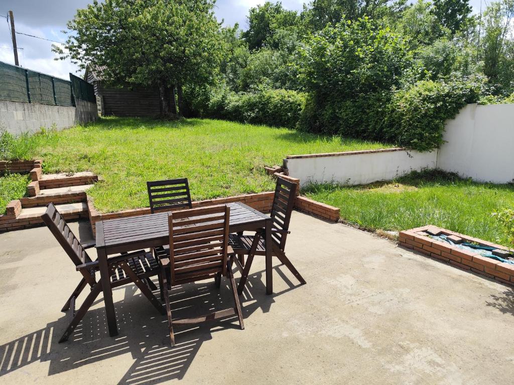 a wooden table with four chairs and a yard at La Petite Maison dans la Prairie in Cholet
