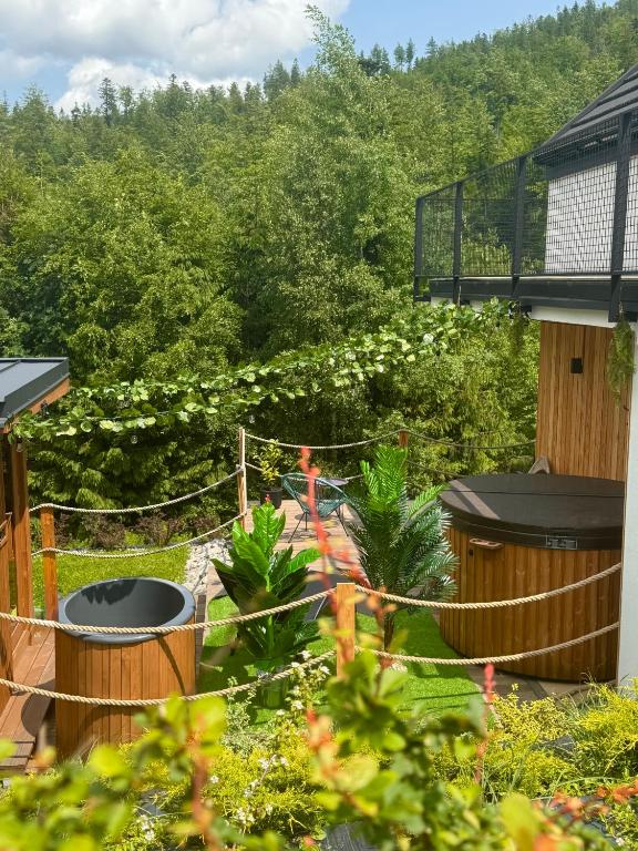 a garden with a fence and plants at Domki Dwa jelonki - balia z jacuzzi i sauna in Wisła