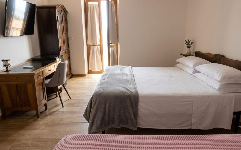 a bedroom with a bed and a desk and a desk at B&B Yle in Cetraro