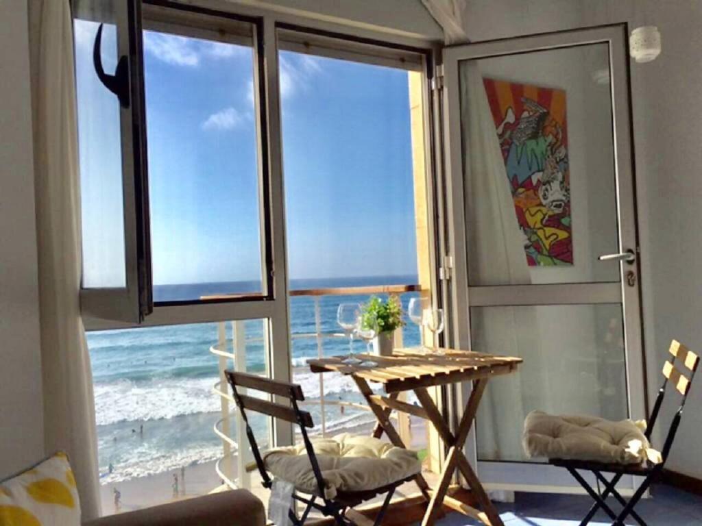 a table and chairs in a room with a view of the ocean at Numancia 1 - 3A in Las Palmas de Gran Canaria