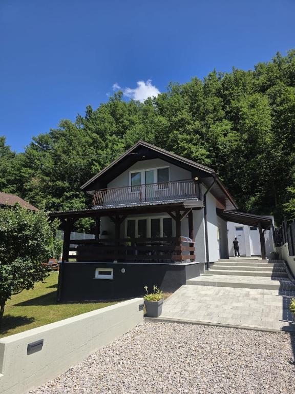 a house with a balcony and stairs in a yard at Vacation Home Belluna in Račić