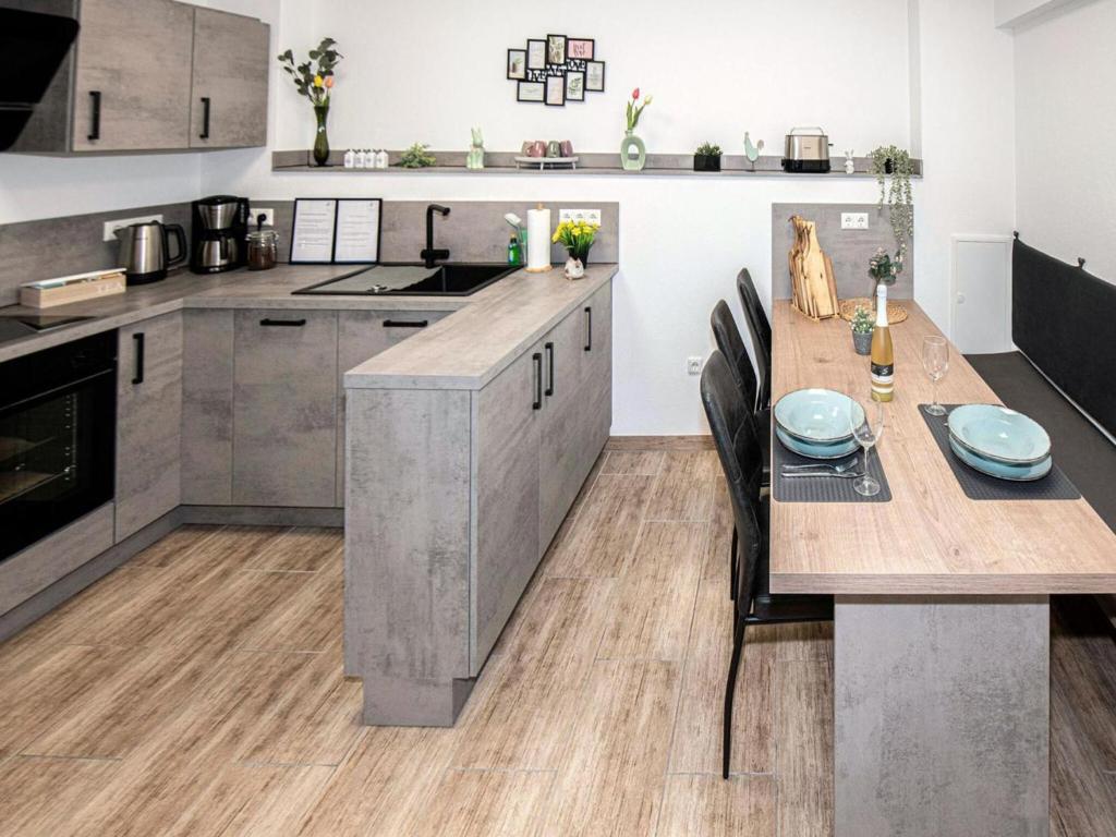 a large kitchen with a wooden table and a table and chairs at FeWo Seidenglanz in Dillenburg