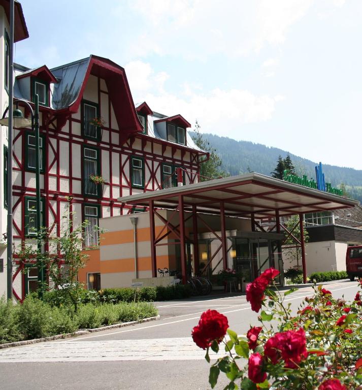 a building with red flowers in front of it at OptimaMed Kurhaus Wildbad in Wildbad Einöd