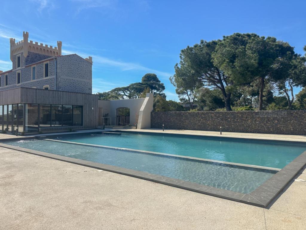 a swimming pool in front of a building at Delya, chalet confort, climatisation, piscine in Agde