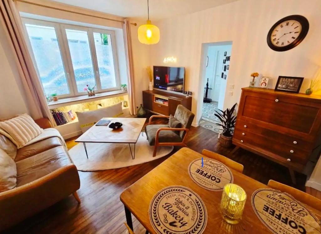a living room with a couch and a table at Au Petit Crecy in Crécy-la-Chapelle