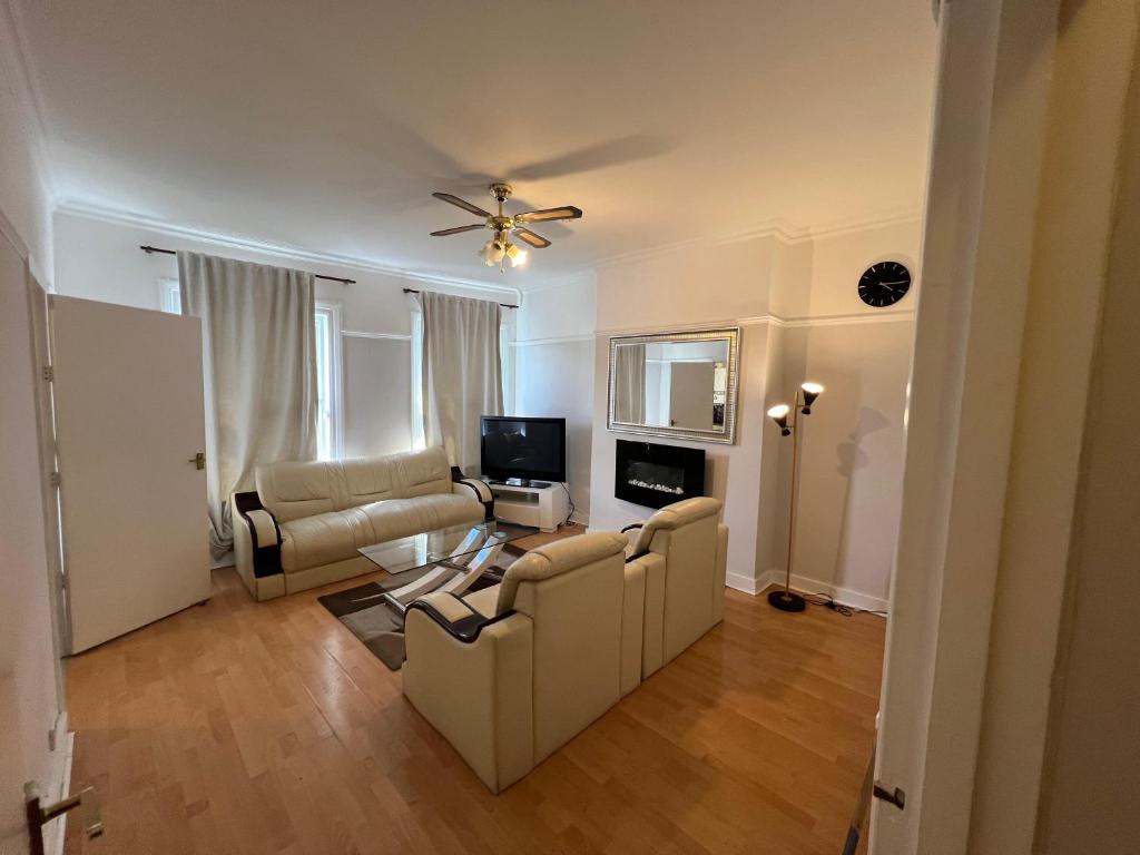 a living room with two couches and a tv at Cozy Spacious Flat in South Norwood