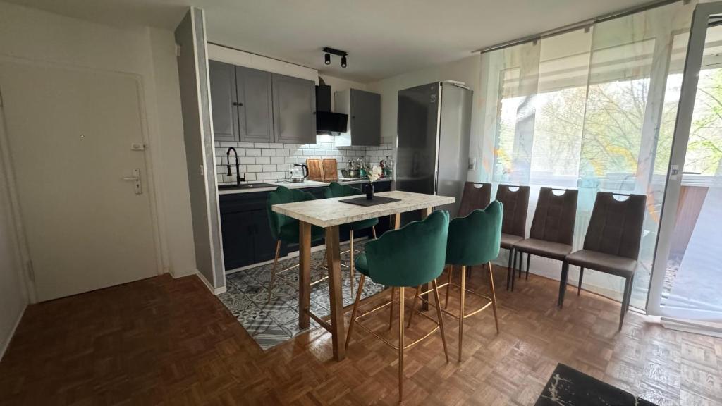 a kitchen with a table and some green chairs at Spacious 3-room apartment with balcony in Mönchengladbach