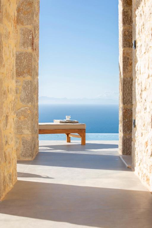 a view of the ocean from a room with a bench at Ionian Horizon Villas in Tsoukalades