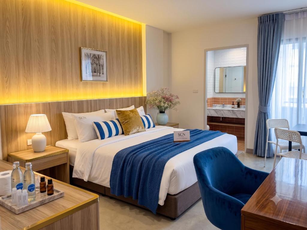 a hotel room with a bed and a blue chair at เดย์ อินน์ บาย วินด์แฮม ระยอง อู่ตะเภา in Ban Chang
