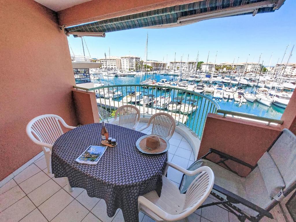 a table and chairs on a balcony with a marina at Apartment Résidence Les Cariatides by Interhome in Fréjus