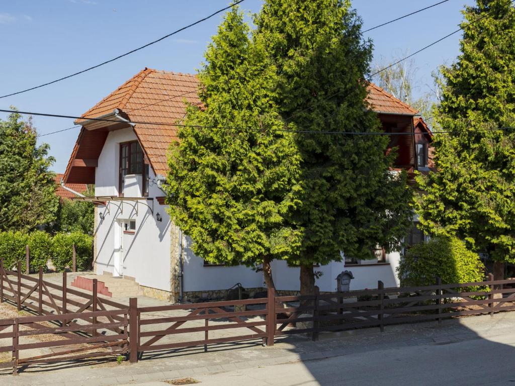 a white house with a fence and two trees at Holiday Home Tamas by Interhome in Balatonőszöd