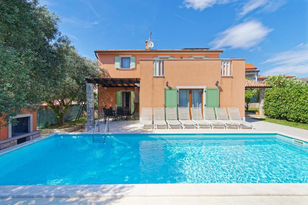 a villa with a swimming pool in front of a house at Villa Ana by Rent Istria in Vilanija