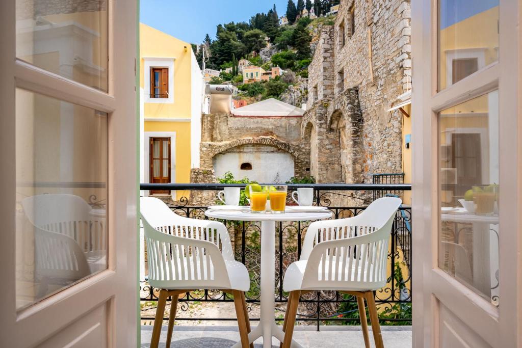 a patio with a table and chairs on a balcony at Symi Duo in Symi