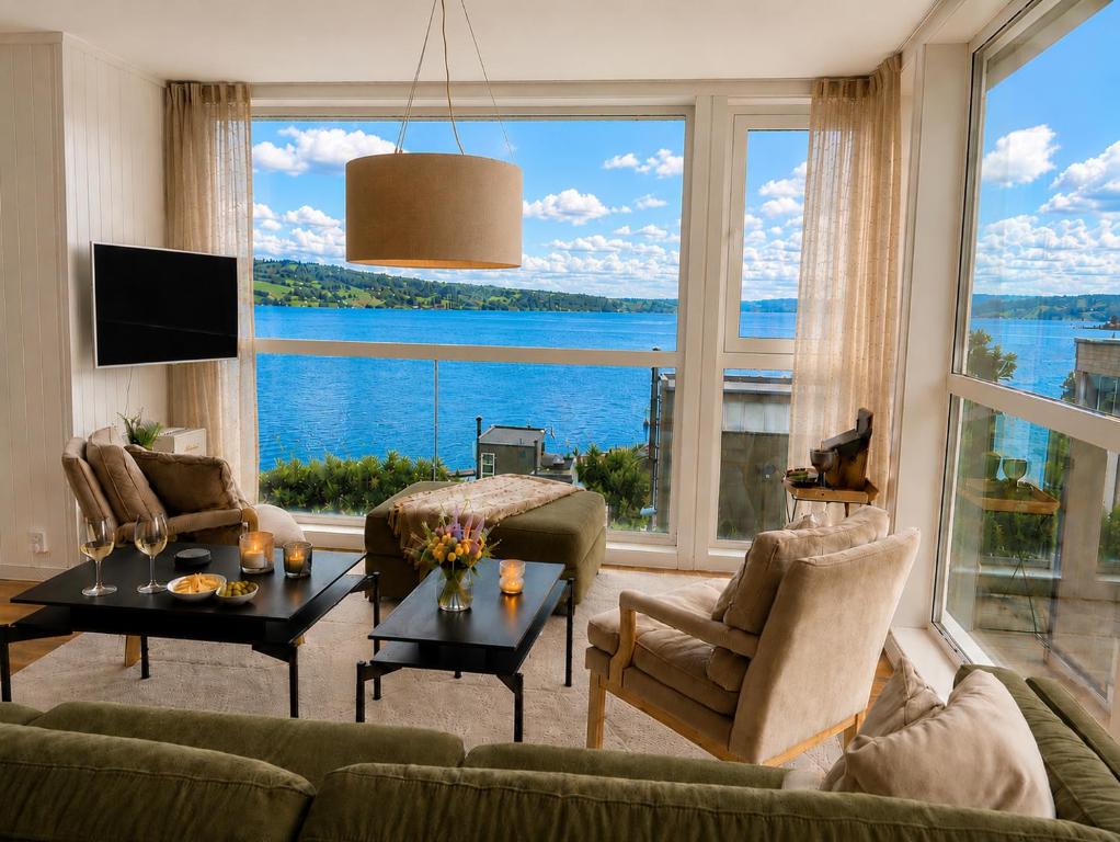 a living room with a large window with a view of the water at Eksklusiv hytte, Utsikt, ro og høy komfort in Gjøvik