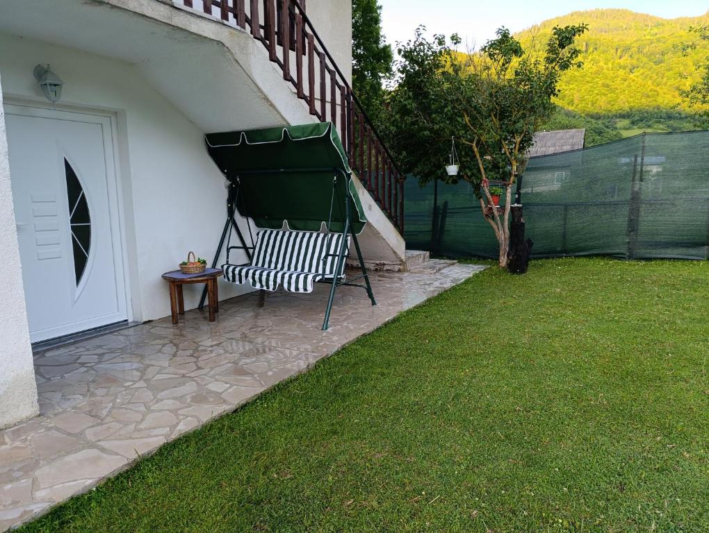 a bench sitting on a patio next to a door at Apartman Dzans in Jajce