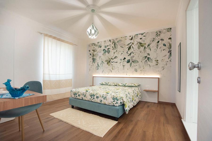 a bedroom with a bed and a wall with flowers at G&G Bed&Breakfast in Bonorva