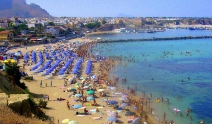 a crowded beach with umbrellas and people in the water at Sabry holiday Terrasini in Terrasini