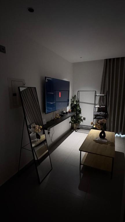 a living room with a chair and a television at KL Studios in Al Khobar
