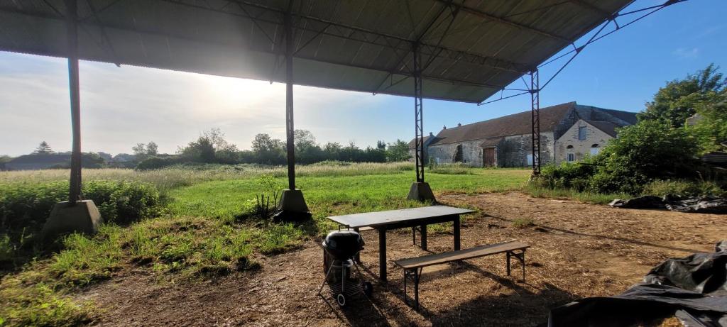 a picnic table and a bench in a field at Gîte de Préaux in Tousson