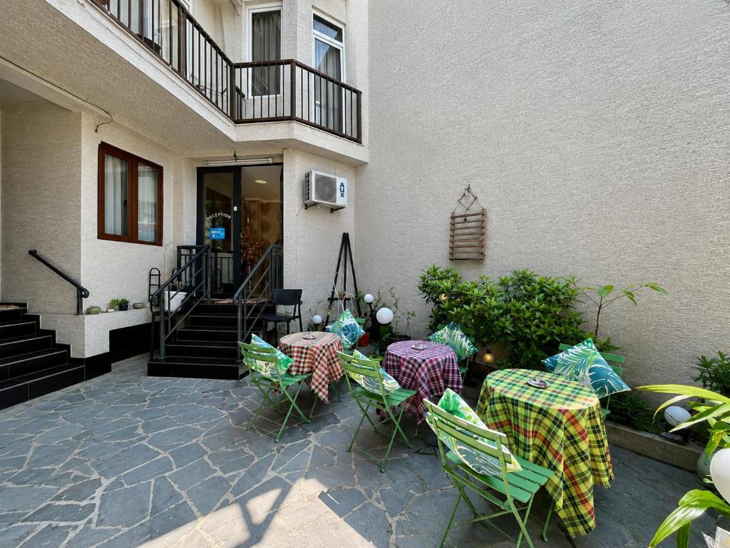 a patio with tables and chairs in front of a building at Old Tbilisi in Itʼkhvisi