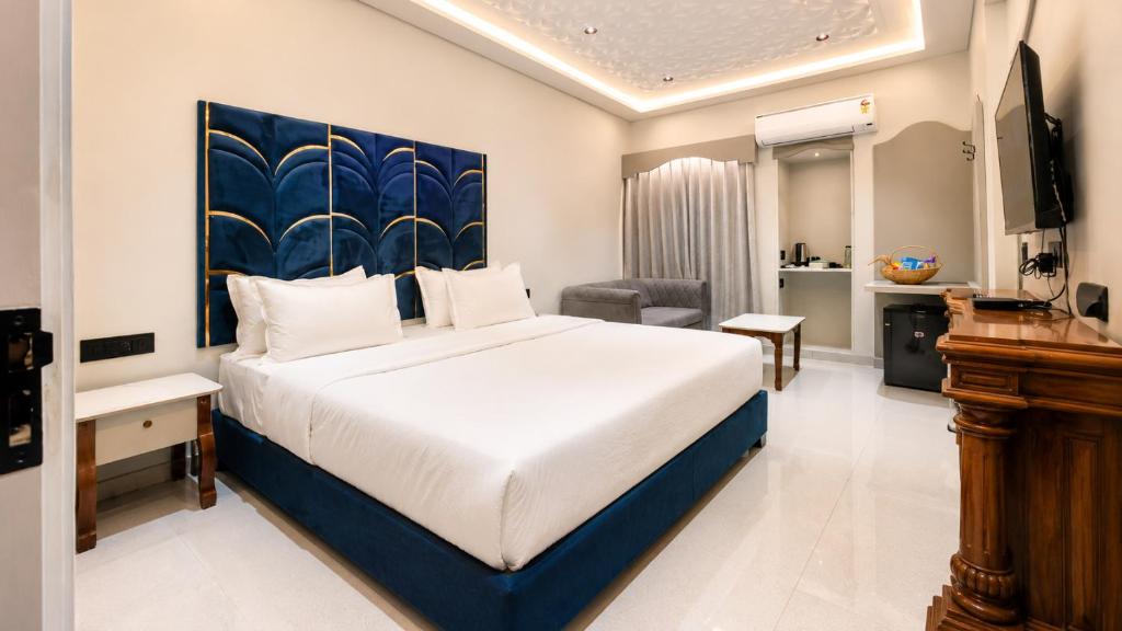 a bedroom with a bed and a desk and a television at Hotel Nova Bloom in Ahmedabad