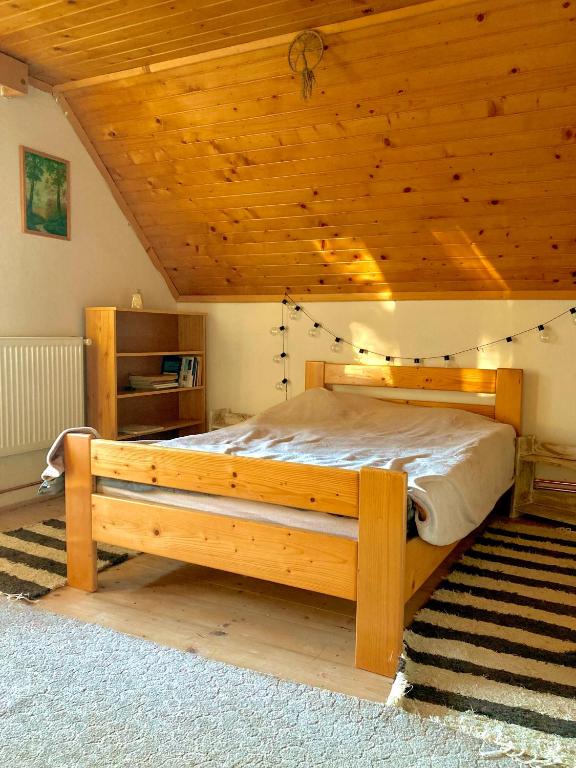 a bedroom with a large bed in a wooden ceiling at Erdei weekend ház in Jögödfürdő