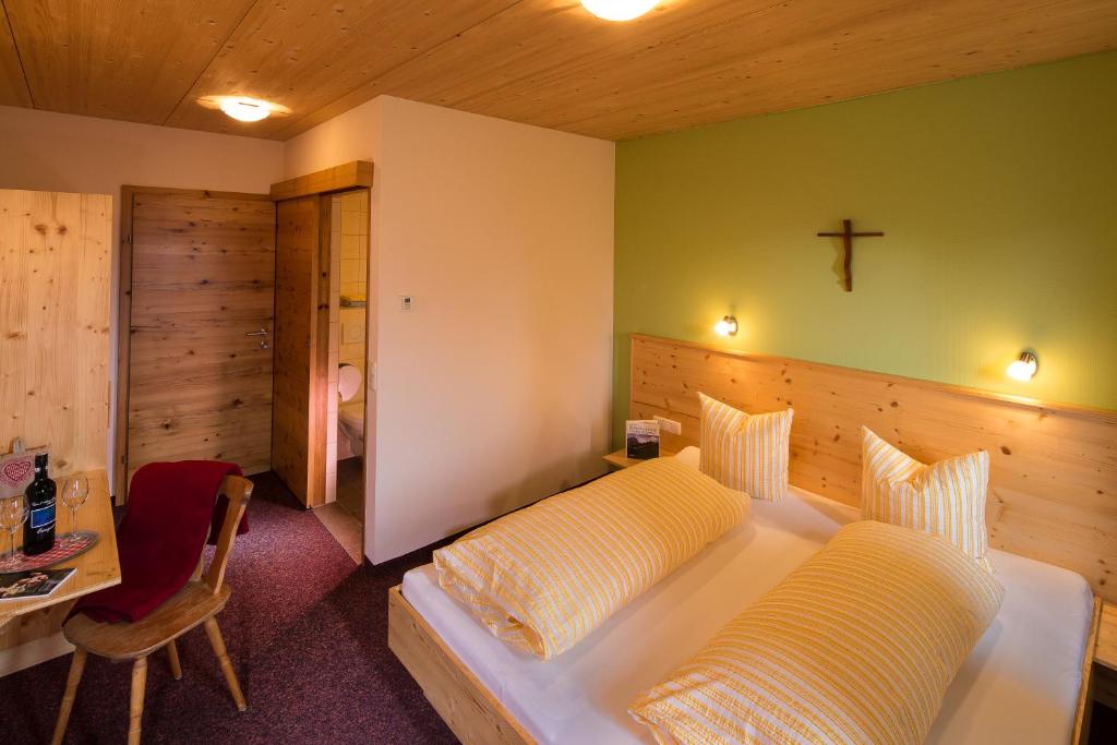 a bedroom with a bed and a cross on the wall at Jägerstüble in Damuls