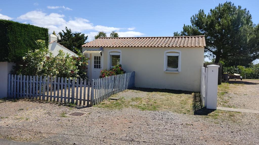 a small white house with a fence in front of it at Le Moulin à Rêves in Talmont