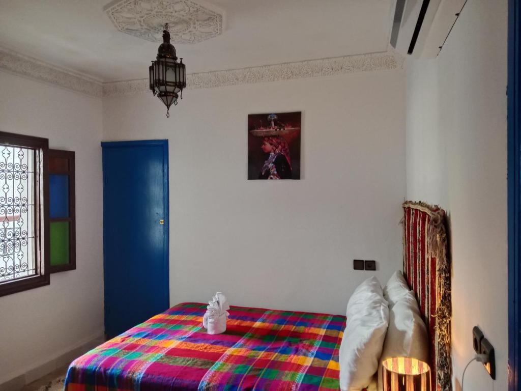 a bedroom with a bed with a colorful blanket at Riad la Fíbula de Nora in Fez