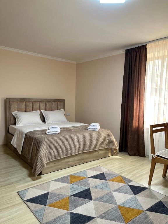 a bedroom with a large bed and a rug at Studio Apartment Goris in Goris