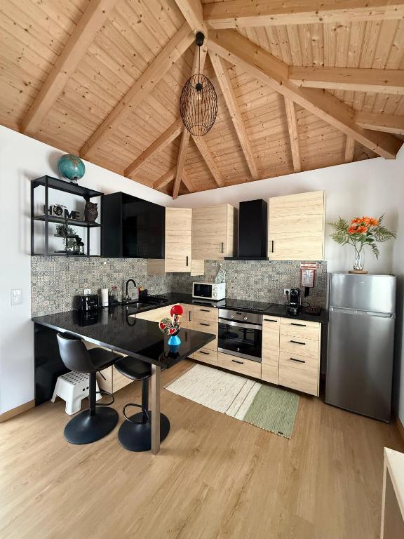 a kitchen with a table and a stainless steel refrigerator at Villa Barbosa in Quintiães