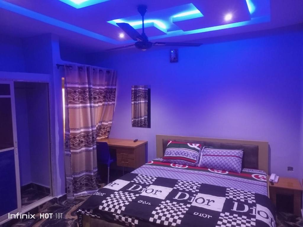 a bedroom with a bed and a blue ceiling at Pleasure rest hotel and suites in Uyo