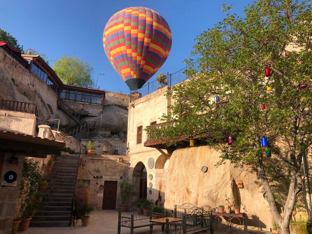 a hot air balloon is flying over a building at Grand Cave Suites in Göreme