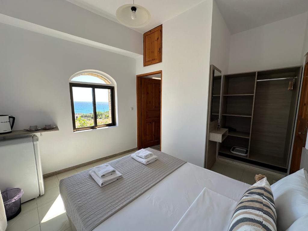 a bedroom with a white bed and a window at Aqua Marine in Falasarna