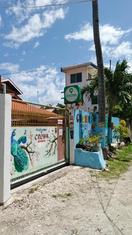 a building with a fence with a peacock painted on it at The Cronin Residence in Oslob
