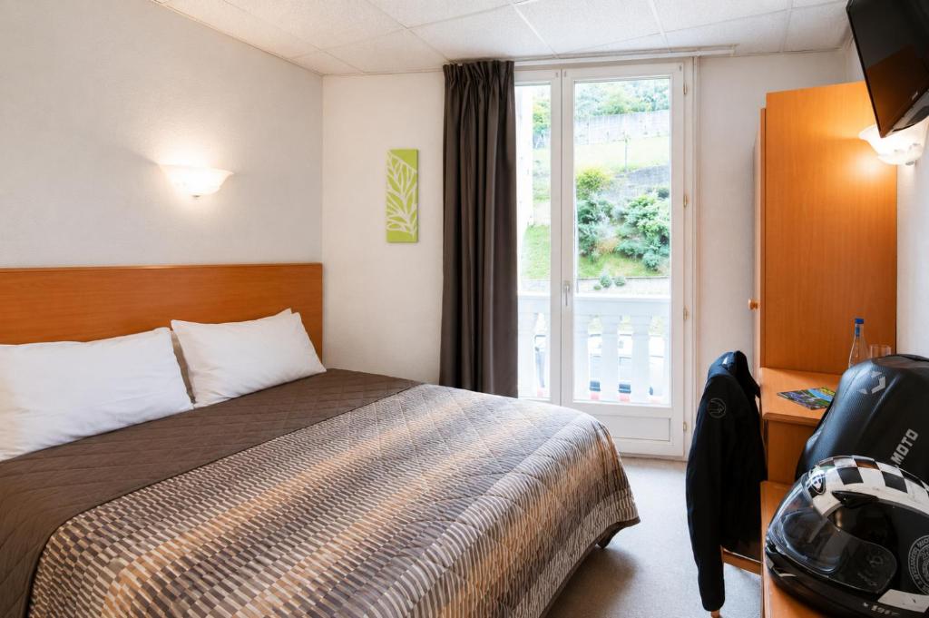 a hotel room with a bed and a window at Hôtel Compostelle in Lourdes