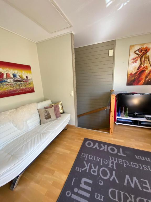 a living room with a white couch and a tv at SV Appartamenty in Horten
