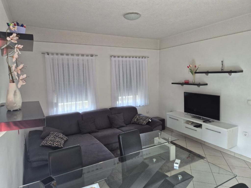 a living room with a couch and a television at Apartman Pecara in Široki Brijeg