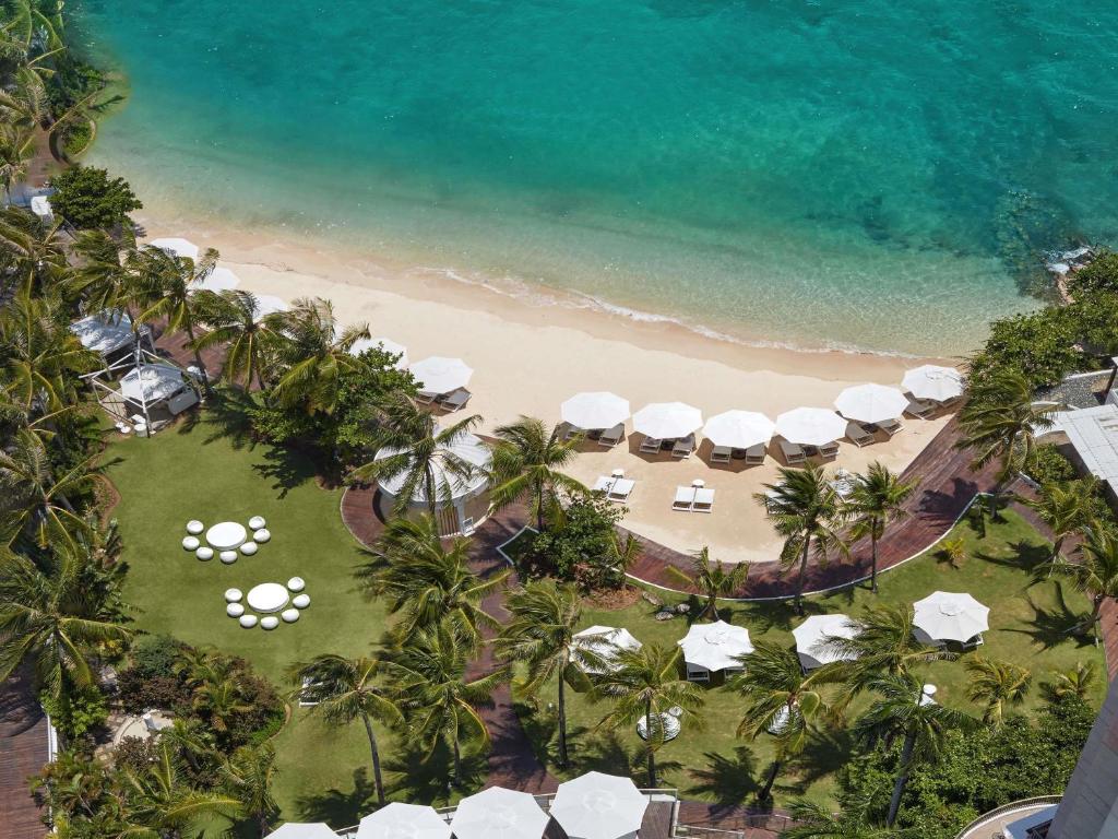 an aerial view of a beach with umbrellas and the ocean at Mövenpick Hotel Mactan Island Cebu in Mactan