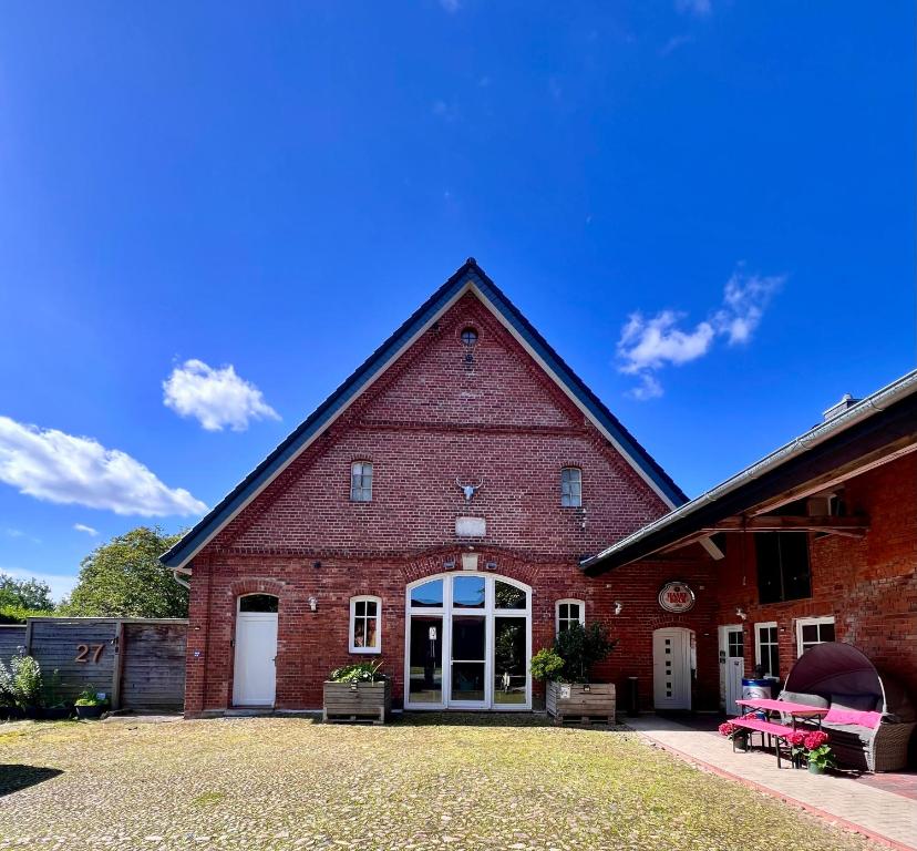 a large red brick building with white doors at HOF27 in Groß Eissel