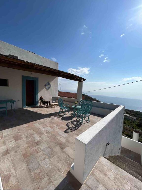 a patio with a table and chairs on top of a house at Melania Home in Filicudi