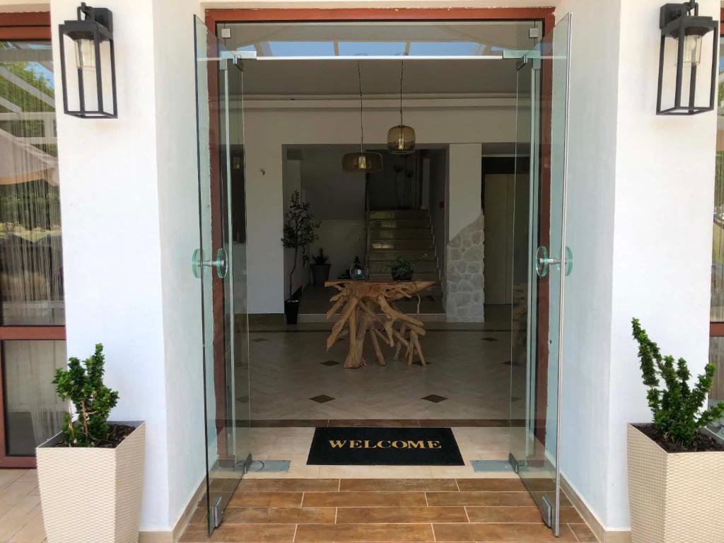 a glass door leading into a lobby with a table at KLIO Apartments and Studios in Nei Poroi